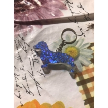 Ezüst kulcskarikán ezüst lánc lóg,kék flitteres tacskó alakú kutya látható.