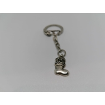 Ezüst kulcskarikára és rövid láncra fűzött, csizma alakú kulcstartó. A csizmában nem felismerhető tárgyak vannak.
