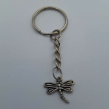 Ezüst kulcskarikára fűzött kulcstartó ezüstszínű szitakötős medállal.