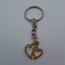 Ezüst kulcskarikára fűzött kulcstartó ezüstszínű arany dupla szíves medállal. 