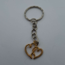 Ezüst kulcskarikára fűzött kulcstartó ezüstszínű arany dupla szíves medállal.