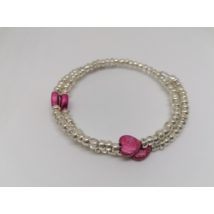Drótra fűzött, a kézen többször körbetekeredő karkötő. 4 mm-es ezüst gyöngyökből készült. A gyöngyök közt időnként rózsaszín, csillogós szívalakú gyöngyök vannak.