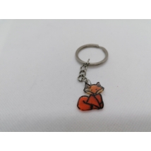 Ezüstszínű kulcskarikára fűzött láncon lógó kulcstartó ülő narancssárga rókával.