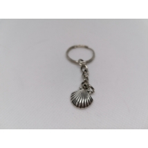 Ezüstszínű kulcskarikáról lánc lóg le, rajta ezüstszínű kagylós medál.