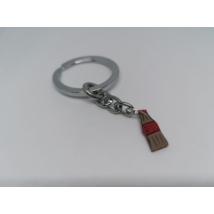 Ezüstszínű kulcskarikáról lánc lóg le, rajta a kulcstartó: kólás palack piros címkével és kupakkal.