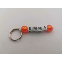 Ezüstszínű kulcskarikáról lelógó Emma szó betűgyöngyökből, két oldalán egy-egy gömbalakú, narancssárga gyönggyel. A betűgyöngyök kockaalakúak, fehér alapon feketék, elforgatva is ugyanazt mutatják.