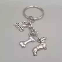Ezüstszínű kulcskarikáról láncon lóg le három különböző szinten három külöböző medál: I szív dogs, csont és egy tacskó.