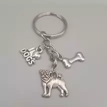 Ezüstszínű kulcskarikáról láncon lóg le három különböző szinten három külöböző medál: I szív dogs, csont és egy mopsz.