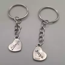 Ezüst kulcskarikára fűzött kulcstartó ezüstszínű, szívalakú anya feliratú medállal. A másik oldalán a felirat: Lánya.