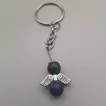 Ezüstszínű kulcskarikáról lelógó angyal kulcstartó: két gömbalakú gyöngy között ezüstszínű, szívmintás szárny, tetején ezüst glória. Az gyöngyök sötétkékek, égszerűek.