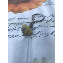 Ezüst kulcskarikán lánc, rajta szemes csavarral rögzített gyantakulcstartó. Citromsárga színű szívet formáz, középen lila folttal.