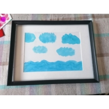 Fekete téglalap alakú keretben, fehér passzpartuval festmény: kék, enyhén hullámzó víz és felhők.