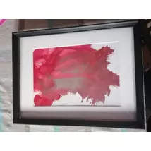 Fekete téglalap alakú keretben, fehér passzpartuval nonfiguratív festmény: vörös folt.