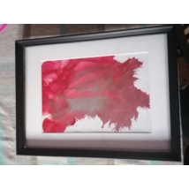Fekete téglalap alakú keretben, fehér passzpartuval nonfiguratív festmény: vörös folt.