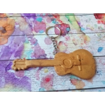 Ezüstszínű kulcskarikáról lelógó láncon kulcstartó: aranyszínű gitár.