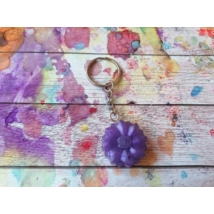 Ezüstszínű kulcskarikáról lelógó láncon kulcstartó: lila margaréta virág.