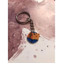 Ezüstszínű kulcskarikáról láncon lóg le egy kotta violin kulccssal
