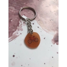 Ezüstszínű kulcskarikáról láncon lóg le egy bicikli.