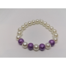 8 mm-es, fehér, gömbalakú gyöngyökből fűzött karkötő, középen 4, tapintható mintás lila gyönggyel, melyeket egy-egy fehér gyöngy választ el.