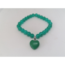 8 miliméteres, gömbalakú türkizkék gyöngyből fűzött gumikarkötő, középen zöldszínű szív medállal. A szívet ezüstszínű akasztó rögzíti a karkötőhöz.