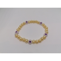 8 mm-es, lila-sárga, gömbalakú gyöngyökből fűzött karkötő, helyenként fehér alapon lila szíves gyöngyökkel, aminek a fehér része foszforeszkál.