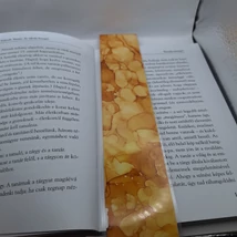 Téglalap alakú könyvjelző, sárga alap barnás részekkel, gömbös mintákkal.