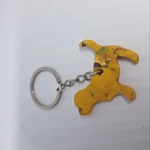 Ezüst kulcskarikáról lánc lóg le, rajta aranyszínű, lapos kutya medál.