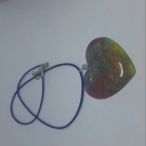Kék zsinóros nyaklánc áttetsző, szív alakú műgyanta medállal, amelyben zöldes, sárgás és rózsaszínes színek keverednek.