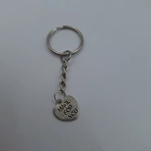 Ezüstszínű kulcstartó apró, szív alakú fém medállal, amelyen a „MADE FOR YOU” felirat olvasható. A medál egyszerű fém lánccal kapcsolódik a kulcskarikához.