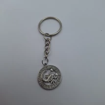 Ezüstszínű kulcskarikáról lánc lóg le, rajta karikában horoszkóp medál. Kívül a 12 hónap jele, belül az aktuális jelkép.