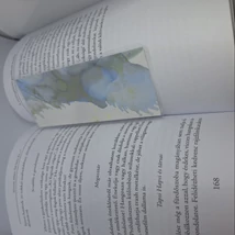 Téglalap alakú könyvjelző: fehér alapon halványkék, világoszöld és szürke árnyalatú, nonfiguratív, akvarellszerű minták díszítik.