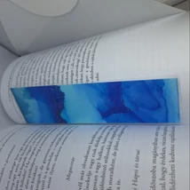 Téglalap alakú könyvjelző, ami a kék különböző árnyalataiban fodrozódik.