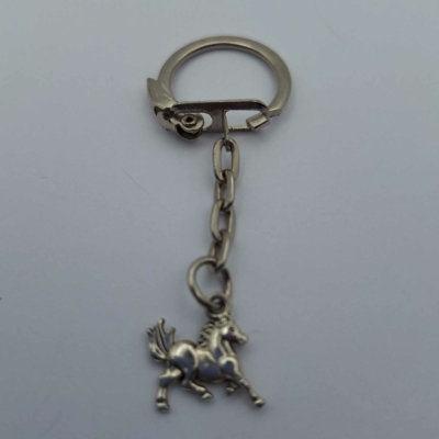 Ezüstszínű kulcskarikára fűzött kulcstartó ló medállal.
