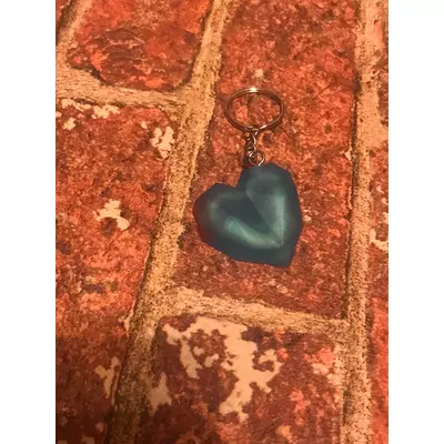 Ezüst kulcskarikán ezüst lánc lóg, kék 3D szív látható. 