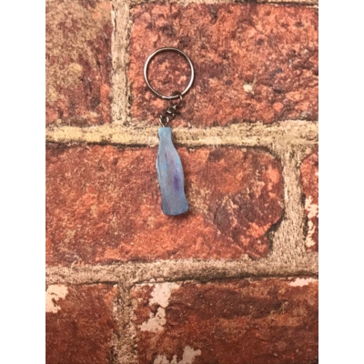 Ezüst kulcskarikán ezüst lánc lóg, kék színű palack tapintható ki.