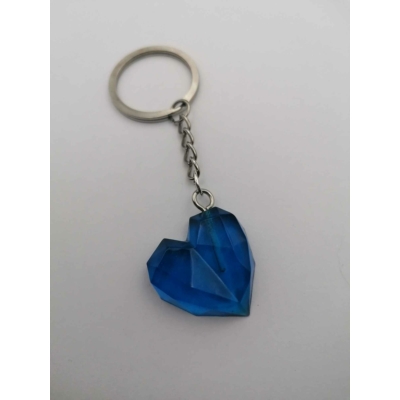 Ezüstszínű kulcskarikán lánc lóg, rajta kristályszerű szív áttetsző kék színben.