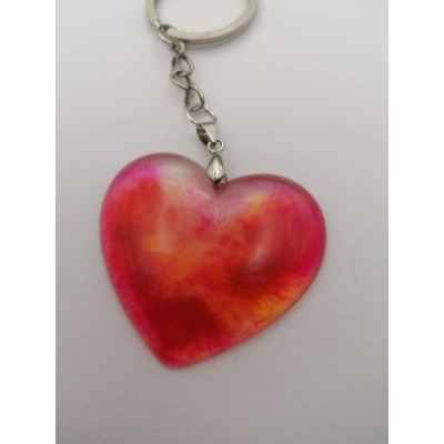 Ezüstszínű kulcskarikán lánc lóg, rajta sima felületű szív piros színben, áttetsző, néhol citromsárga is megjelenik.