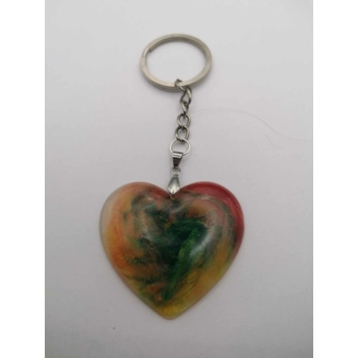 Ezüstszínű kulcskarikán lánc lóg, rajta sima felületű szív, amiben zöld, sárga és egy kis piros örvénylik.