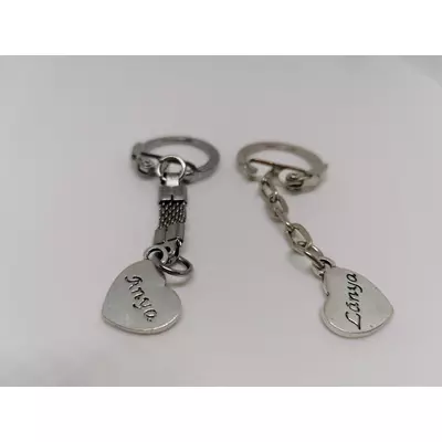 Ezüst kulcskarikára fűzött kulcstartó ezüstszínű anya- lánya medállal.