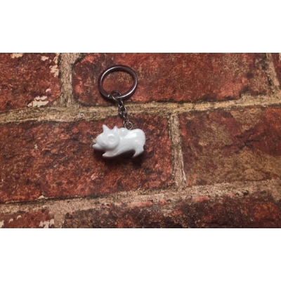 Ezüst kulcskarikán ezüst lánc lóg, előre néző fehér színű cica.