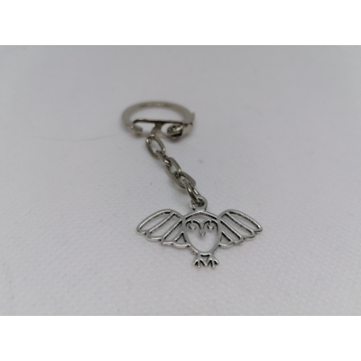 Ezüstszínű kulcskarikáról lánc lóg le, rajta ezüstszínű szárnyát széttáró baglyos medál.