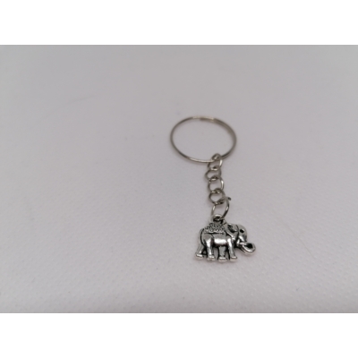 Ezüstszínű kulcskarikáról lánc lóg le, rajta ezüstszínű elefánt medál. Az elefánt hátán nyeregszerű ponyva.
