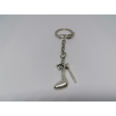 Ezüstszínű kulcskarikára rögzített láncról lelógó ezüstszínű nagy magassarkú cipő kulcstartó. A tetején nagy masni.