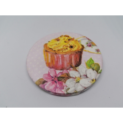 Köralakú hűtőmágnes középen barna, sárga krémes muffinnal, körülötte halványrózsaszín és fehér virágokkal és egy teáscsésze szélével.