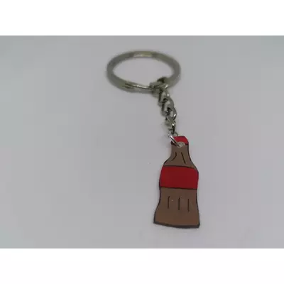 Ezüstszínű kulcskarikáról lánc lóg le, rajta a kulcstartó: kólás palack piros címkével és kupakkal.