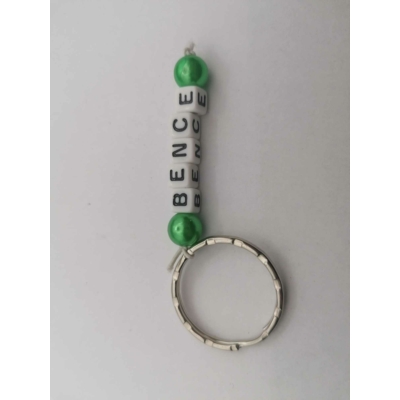 Ezüstszínű kulcskarikáról lelógó Bence szó betűgyöngyökből, két oldalán egy-egy gömbalakú, zöld gyönggyel. A betűgyöngyök kockaalakúak, fehér alapon feketék, elforgatva is ugyanazt mutatják.