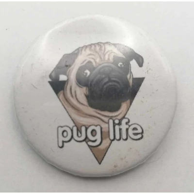Köralakú kitűző: háromszög alakból kibújó bézs mopsz, alatta fehérrel a felirat: pug life.