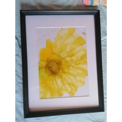 Fekete téglalap alakú keretben, fehér passzpartuval festmény: sárga virág.
