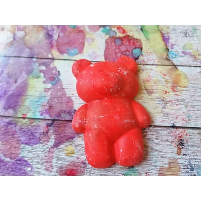 Narancssárgás piros mackó. Alakján tapintható feje, pocakja, végtagjai, fülei és az orra.