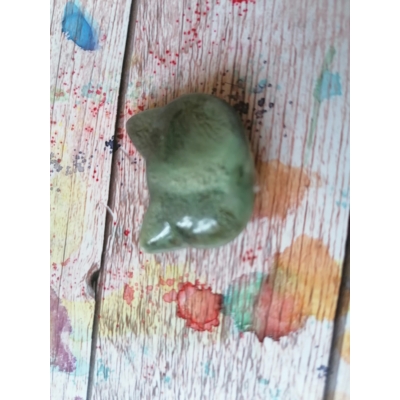 Középzöld macskafej alakú apró mágnes. A körvonal, a fülek tapinthatók, konkrét arca nincs.